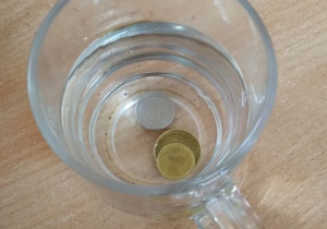 Moneta tonie w szklance z wodą